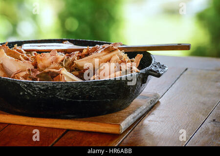 Gegrilltes mariniertes Grillfleisch (Kebab) Huhn am Spieß aus Metall. BBQ Grill. Fleischscheiben in einer schwarzen Pfanne serviert. Stockfoto