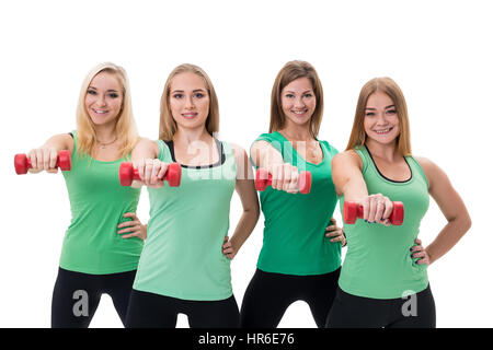 Hübschen Sportlerinnen im grünen Spitzen und schwarzen Leggings posiert im Studio mit roten Hanteln in die Hände Stockfoto