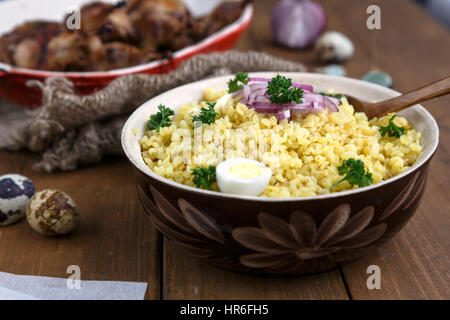 Östlichen traditionellen Weizen Brei - Bulgur in einer Schüssel Lehm auf dunklem Holz Stockfoto