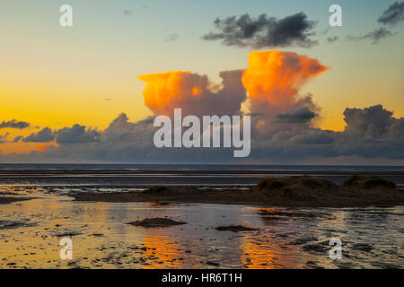 Gewitterwolken, Cumulonimbus-Formationen in Southport, Merseyside, Großbritannien. Februar 2017. Wetter. Sonnenuntergang über Ainsdale Beach als orangefarbene Cumulus Congestus Wolken, auch bekannt als majestätische Cumulus Form am Horizont über der Irischen See. Diese dichten Formationen gehen mit Gewitter und atmosphärischer Instabilität einher, die sich aus Wasserdampf bilden, der von starken Luftströmen nach oben getragen wird. Werden diese Wolken bei einem Sturm beobachtet, werden sie als Gewitter bezeichnet. Stockfoto