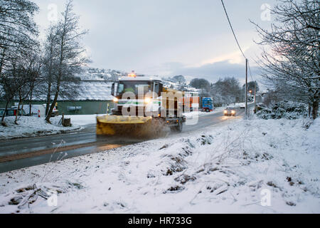 Ein Schneepflug clearing und knirschte ein ländliches Dorf Straße Schnee im Dorf Rhosesmor, Flintshire Stockfoto