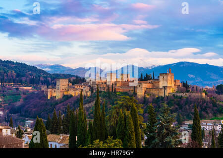 Alhambra-Palast bei Sonnenuntergang mit schneebedeckten Bergen der Sierra Nevada im Hintergrund. Granada, Andalusien, Spanien Stockfoto