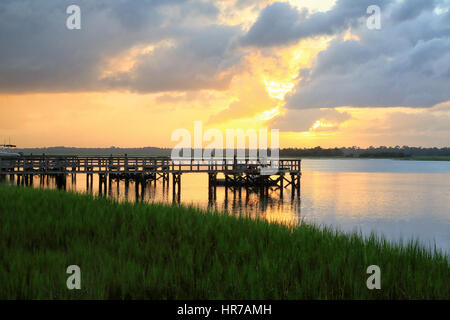 Sonnenuntergang über der Kiawah River auf Kiawah Island, South Carolina. Die Silhouette von mehreren Anlegestellen ist Licht mit Sonnenuntergang. Stockfoto