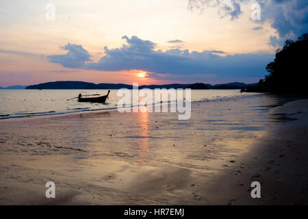 Ein Thai Longtail-Boot vertäut Ao Nag Strand bei Sonnenuntergang, Ao Nang, Krabi Provinz, Thailand. Stockfoto