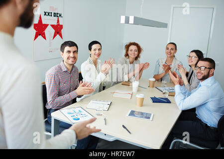 Gruppe von Menschen gekleidet im Business casual lächelnd und applaudieren, Gruß der Mann an der Spitze vor ihnen Seminar stehen im Tagungsraum Stockfoto