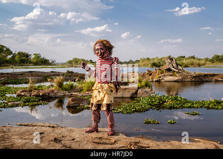 Mann verkleidet als ein Makishi posiert für die Kamera von der Zambezi River Bank. Die Makishi ist ein Charakter, der für die nordwestlichen Völker Lebensart Sambia Stockfoto