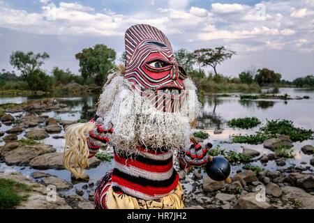 Mann verkleidet als ein Makishi posiert für die Kamera von der Zambezi River Bank. Die Makishi ist ein Charakter, der für die nordwestlichen Völker Lebensart Sambia Stockfoto