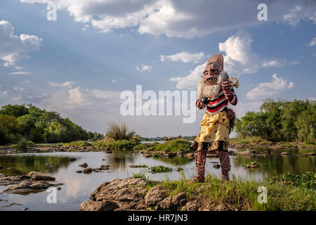 Mann verkleidet als ein Makishi posiert für die Kamera von der Zambezi River Bank. Die Makishi ist ein Charakter, der für die nordwestlichen Völker Lebensart Sambia Stockfoto