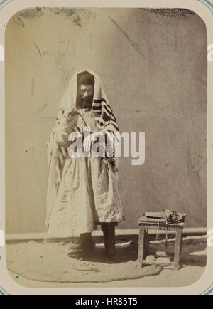 Ein jüdischer Mann in Samarkand, Zeravshan Okrug, der einen Gebetsschal trägt und seinen Arm in ein Phylakterium wickelt, zur Vorbereitung auf das Gebet, von Aleksandr L. Kun, einem russischen Orientalisten, in den 1860er Jahren oder 1872. Stockfoto
