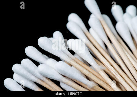 Haufen von Wattestäbchen, Q-Tipps, wie ein Fächer ausgebreitet. Die Abstriche werden vor einem schwarzen Hintergrund fotografiert. Stockfoto