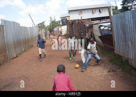 Kinder spielen Fußball auf der Straße, in Kibera Slum, Nairobi, Kenia, Ostafrika Stockfoto