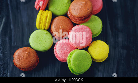 bunte Macarons auf schwarzem Hintergrund Stockfoto