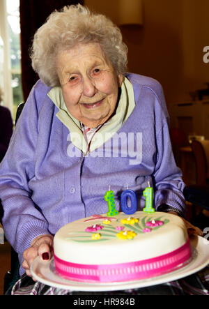 Ältere Frau im Rollstuhl halten ihre Geburtstagstorte feiert ihr 101 Jahre, in Wohn-Pflegeheim, Alton, Hampshire, UK. 26. Februar 2017. Stockfoto
