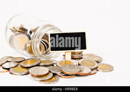 Münzen in Geld Glas mit schwarzem Holz Tag für Ihren Text isoliert auf weißem Hintergrund. Stockfoto