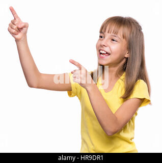 Emotionale Brustbild des Kaukasischen Mädchen mit gelben T-shirt. Lustige Kinder zeigen und auf der Suche nach oben während lächelnd, isoliert am Pfingstmontag Stockfoto