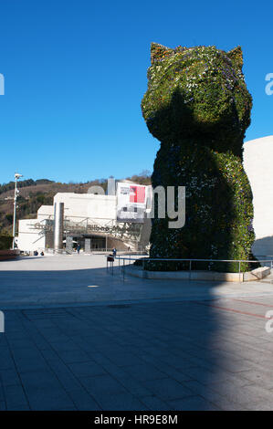 Spanien: die Blume Skulptur Puppy, gegründet 1992 von Jeff Koons am Eingang des Guggenheim Museum Bilbao und Blick auf die Skyline der Stadt Stockfoto