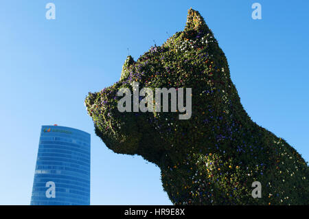Spanien: die Blume Skulptur Puppy, gegründet 1992 von Jeff Koons am Eingang des Guggenheim Museum Bilbao und Blick auf die Skyline der Stadt Stockfoto