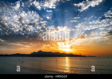 Mallorca-Puerto de Alcudia Beach Pier bei Sunrise in Alcudia Bucht auf Mallorca Balearen Spanien. Sonnenaufgang über den Bergen im Meer Stockfoto