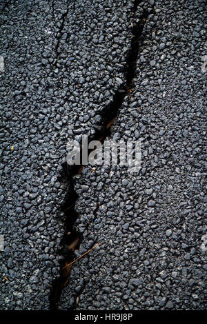 Rissigen Asphalt Fahrbahn mit gelben Traffic Line Stockfoto