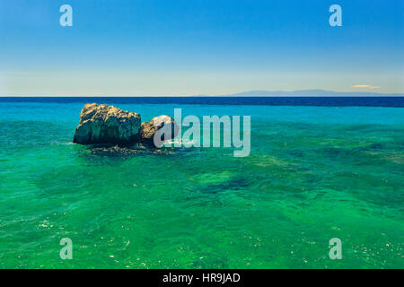 Die felsige Küste mit Blick auf das türkisblaue Meer in den warmen Sommertag. Griechenland. Chalkidiki Stockfoto