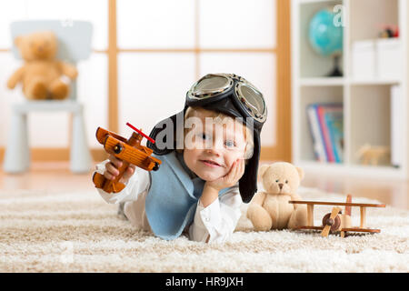 Porträt des kleinen Jungen spielen mit hölzernen Flugzeug Stockfoto