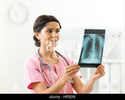 Junge Ärztin Blick auf der Röntgenaufnahme der Lunge im Krankenhaus Stockfoto