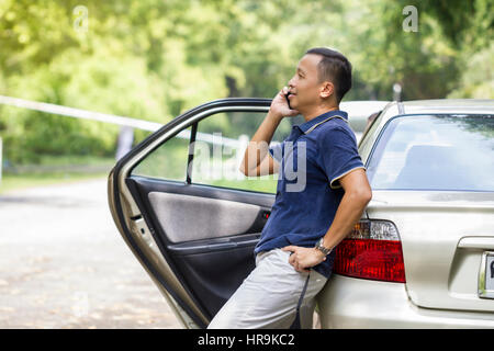 Junger Mann mit Handy und nehmen Sie eine Pause im park Stockfoto