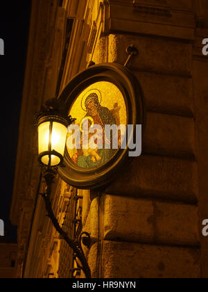 Eine kleine Madonna oder Madonnelle leuchtet auf einer Straßenecke in der Nacht in Rom. Stockfoto