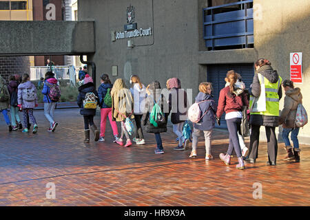 Grundschule Mädchen zu Fuß durch eine Vorwerk-zustandes Innenhof mit einem Lehrer im Winter Sonnenschein zentrale Stadt der London UK KATHY DEWITT Stockfoto