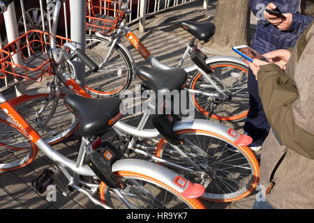 Leute benutzen Bike-Sharing APP, Fahrradverleih in Peking, China. 28. Februar 2017 Stockfoto