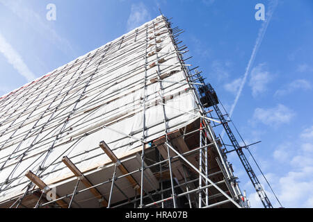 weißes Tuch am Gerüst der hohen Neubau mit Aufzug und blauer Himmel Stockfoto