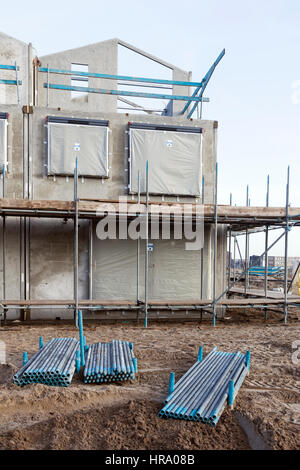 Betonrahmen des neu erbauten Hauses mit Gerüst rund und Metallrohre Stockfoto