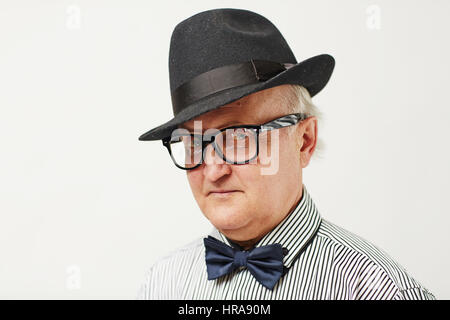 Porträt von Ernst älterer Mann mit schwarzem Hut und Fliege Blick in die Kamera durchdringend, Argwohn und Misstrauen zeigen Stockfoto