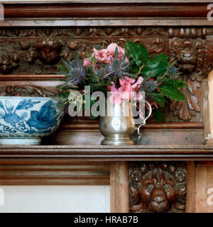 Blumen und eine Schale auf einem Kaminsims. Stockfoto