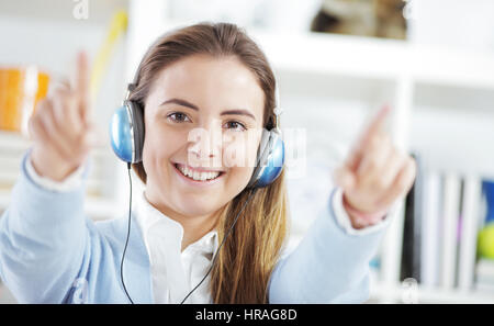 Glückliche junge Frau trägt Kopfhörer, Musik hören Stockfoto