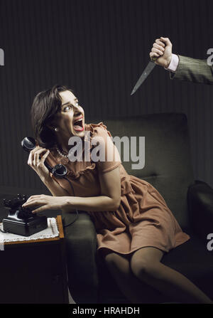 Verängstigte Frau von einem Mann Mörderin mit einem Messer Stockfoto