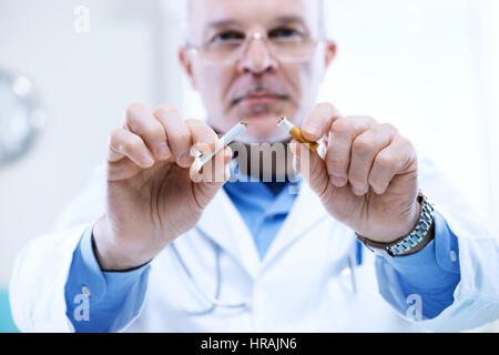 Leitender Arzt bricht eine Zigarette, Stop-Smoking-Konzept. Stockfoto