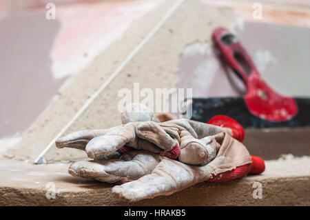 Kamin-Oberfläche mit Spackle und Kelle eigenhändig zu reparieren Stockfoto
