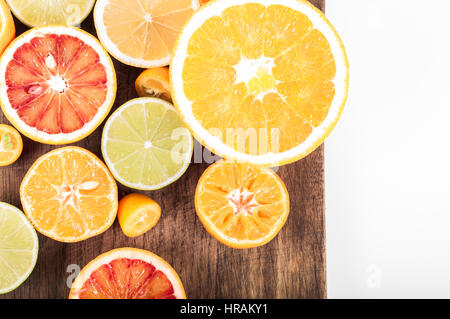 Bunte frische Zitrusfrüchte auf hölzernen Hintergrund. Orange, Mandarine, Limette, Blutorange, Grapefruit. Obst-Hintergrund. Sommer-Food-Konzept. Flache lay Stockfoto