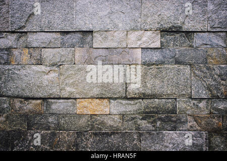 Mauer aus Granit / Steinmauer Nahaufnahme Foto Hintergrundtextur. Farbfilter-Effekte und Lärmbelästigungen feinen Film hinzugefügt. Stockfoto