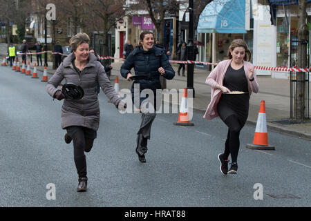 Grove, Ilkley, West Yorkshire, Großbritannien. 28. Februar 2017. Weibliche Teilnehmern sind beteiligen und im traditionellen, jährlichen Ilkley Rotary Pfannkuchen Rennen laufen. Bildnachweis: Ian Lamond/Alamy Live-Nachrichten Stockfoto