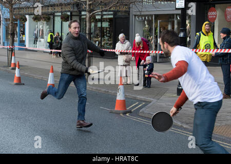 Grove, Ilkley, West Yorkshire, Großbritannien. 28. Februar 2017. Erwachsene männliche Läufer teilnehmen in der traditionellen, jährlichen Ilkley Rotary Pancake Race - eine Kollision ist hier geschehen. Bildnachweis: Ian Lamond/Alamy Live-Nachrichten Stockfoto