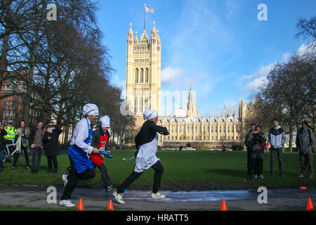 Victoria Tower Gardens, London, UK. 28. Februar 2017. Tim Loughton, MP für Ost Worthing und Shoreham, George Parker, politischer Redakteur, Financial Times. Lords, Abgeordnete und Mitglieder des Media-Teams nehmen Teil in Pfannkuchen-Rennen - wir feiern 20 Jahre flipping für Reha-Nächstenliebe und seine Arbeit mit behinderten Menschen. Bildnachweis: Dinendra Haria/Alamy Live-Nachrichten Stockfoto