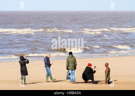 Crosby, Liverpool, UK. 1. März 2017. Großbritannien Wetter in Merseyside. Mensch und Hund Wanderer auf Crosby Strand nahe Liverpool, den 1. Tag des Frühlings genießen. Ein Tag Wolken und Sonne, sondern mit einer Erwartung von wärmeren Temperaturen zu folgen. Crosby Strand ist der Ort, wo 100 Ironmen aufgestellt werden, ein Kunstwerk von Antony Gormley unter dem Titel "Woanders". Bildnachweis: Cernan Elias/Alamy Live-Nachrichten Stockfoto