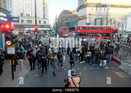 Rote Doppeldeckerbusse, Verkehr und Fußgänger, die Straßen an der belebten Oxford Street überqueren St Tottenham Court U-Bahnstation Crosswalk London UK KATHY DEWITT Stockfoto