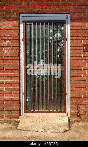 Die Bars und die Einschusslöcher in der Tür dieses verlassene Geschäfte in einer wirtschaftlich notleidende Bereich von Tennessee zeigt, hoher Kriminalität und Gefahren. Stockfoto