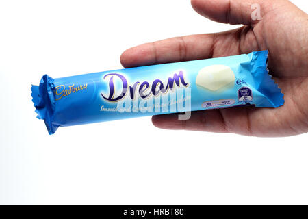 Hand, die weiße Australien Cadbury Schokoriegel auf weißen Hintergrund isoliert Stockfoto