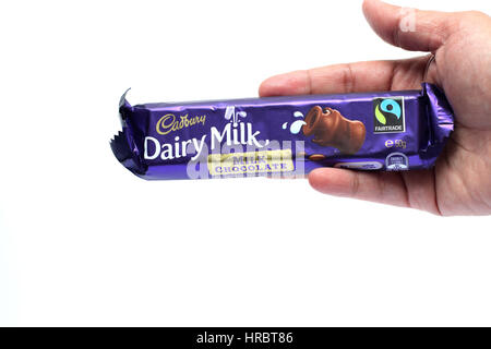 Hand hält Australien Cadbury dairy Milch Schokoriegel isoliert gegen Kuhmilch Hintergrund Stockfoto