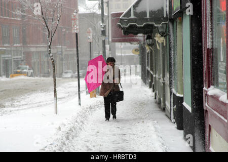 Schneesturm downtown Portland Maine Frau zu Fuß Bürgersteig Winter Sturm Schnee New England USA Wetter kaltes Eis Winter Wind Regenschirm Stockfoto