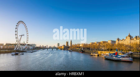 Londons Skyline Blick bei Sonnenaufgang mit berühmten Wahrzeichen, Big Ben, Houses of Parliament und Schiffe auf der Themse mit klaren blauen Himmel - England, UK Stockfoto